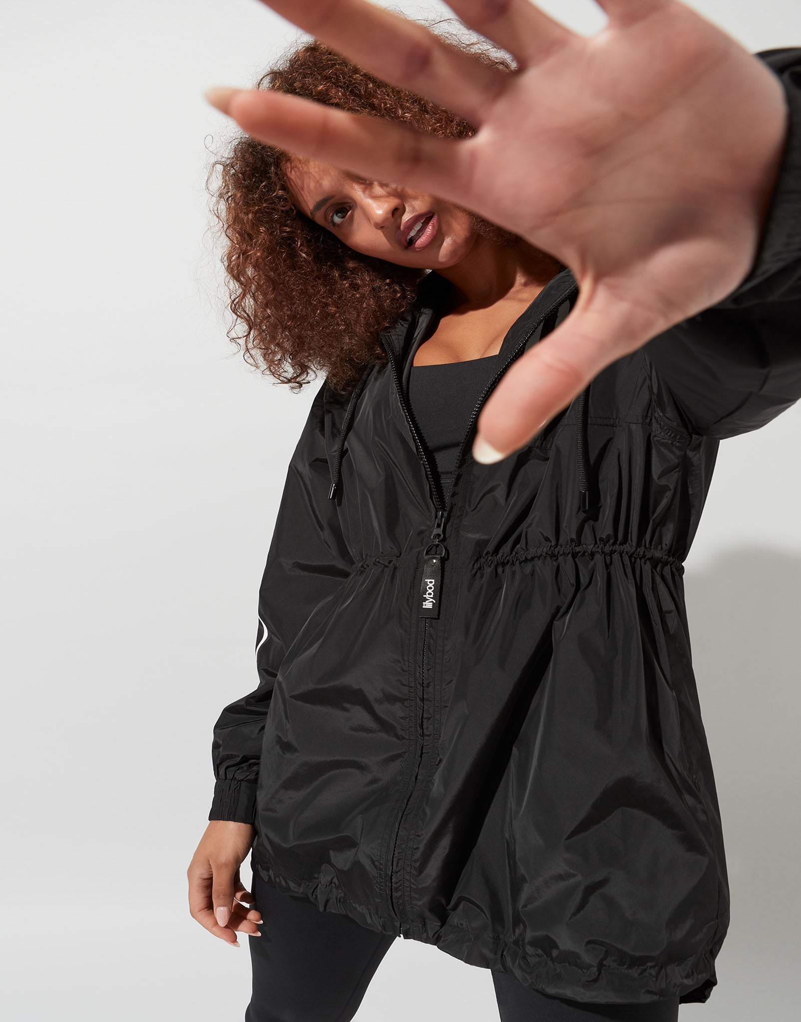 A woman wearing a black activewear jacket and leggings