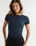 A woman wearing a navy blue t-shirt and black leggings