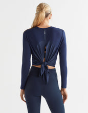 Navy blue athletic outfit with a tie detail on a white background