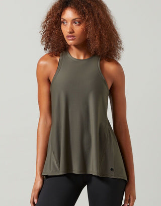 A woman wearing a green Lilybod Kendell Activewear Tank Tarmac top with a tie-up front and an open back.