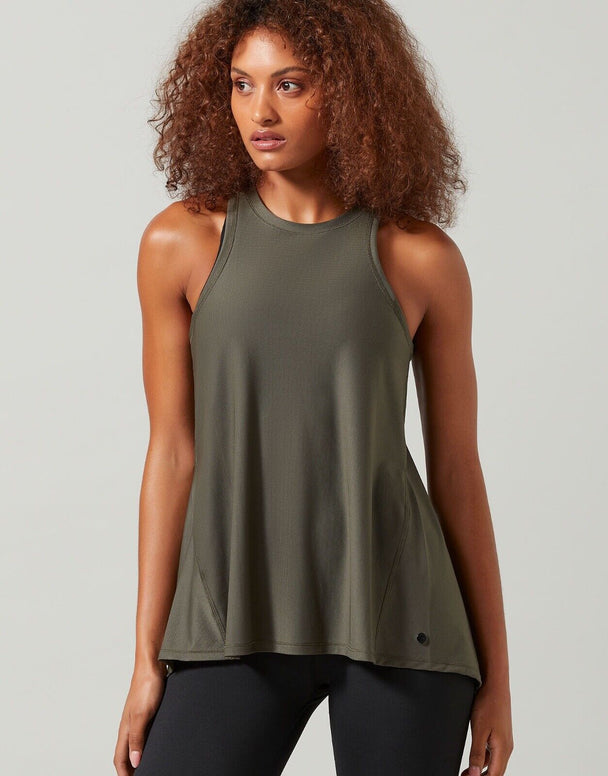 A woman wearing a green Lilybod Kendell Activewear Tank Tarmac top with a tie-up front and an open back.