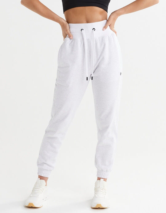 A pair of relaxed fit sweatpants in misty grey marle and bright white, shown in a standing position with hands on hips.