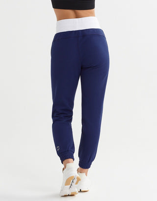 Rear view of a woman wearing blue and white joggers and white shoes