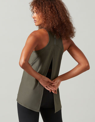 A woman wearing a green Lilybod Kendell Activewear Tank Tarmac top with a tie-up back.