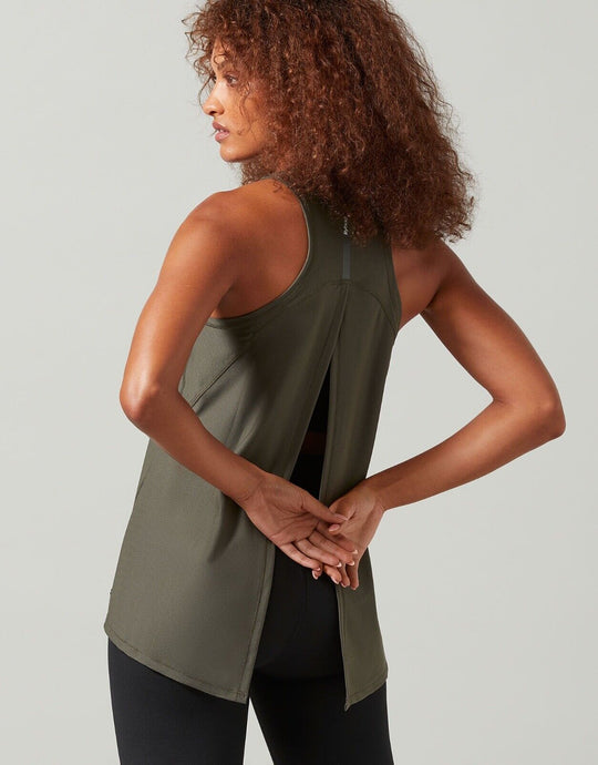 A woman wearing a green Lilybod Kendell Activewear Tank Tarmac top with a tie-up back.