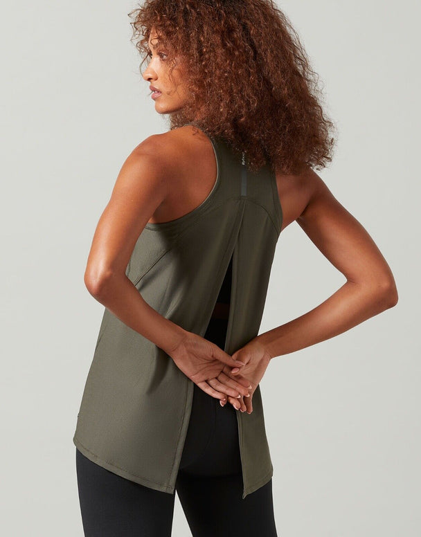 A woman wearing a green Lilybod Kendell Activewear Tank Tarmac top with a tie-up back.