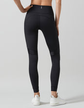 Black leggings worn by a person on a light gray background