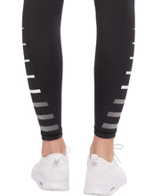 Black leggings with white stripe design worn by a person, on a white background