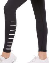 Black leggings with white and gray stripe design worn by a person on a white background