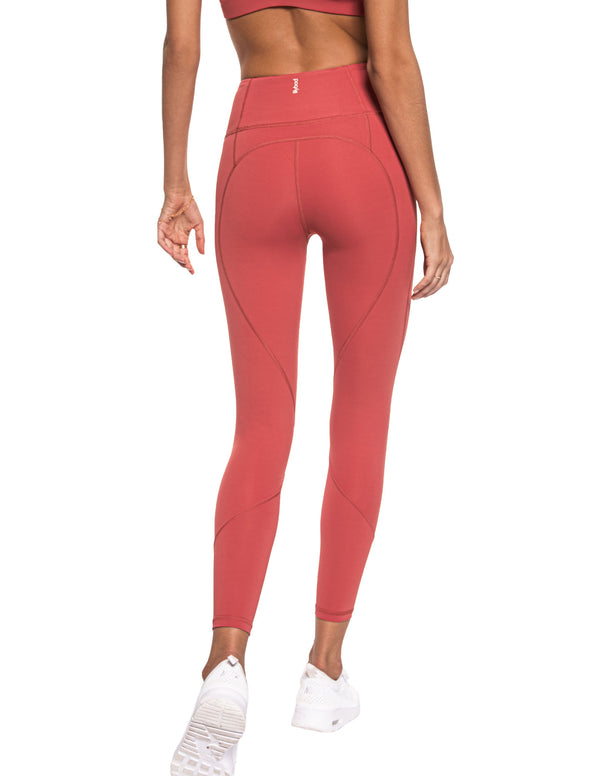 Person wearing coral pink leggings on a white background