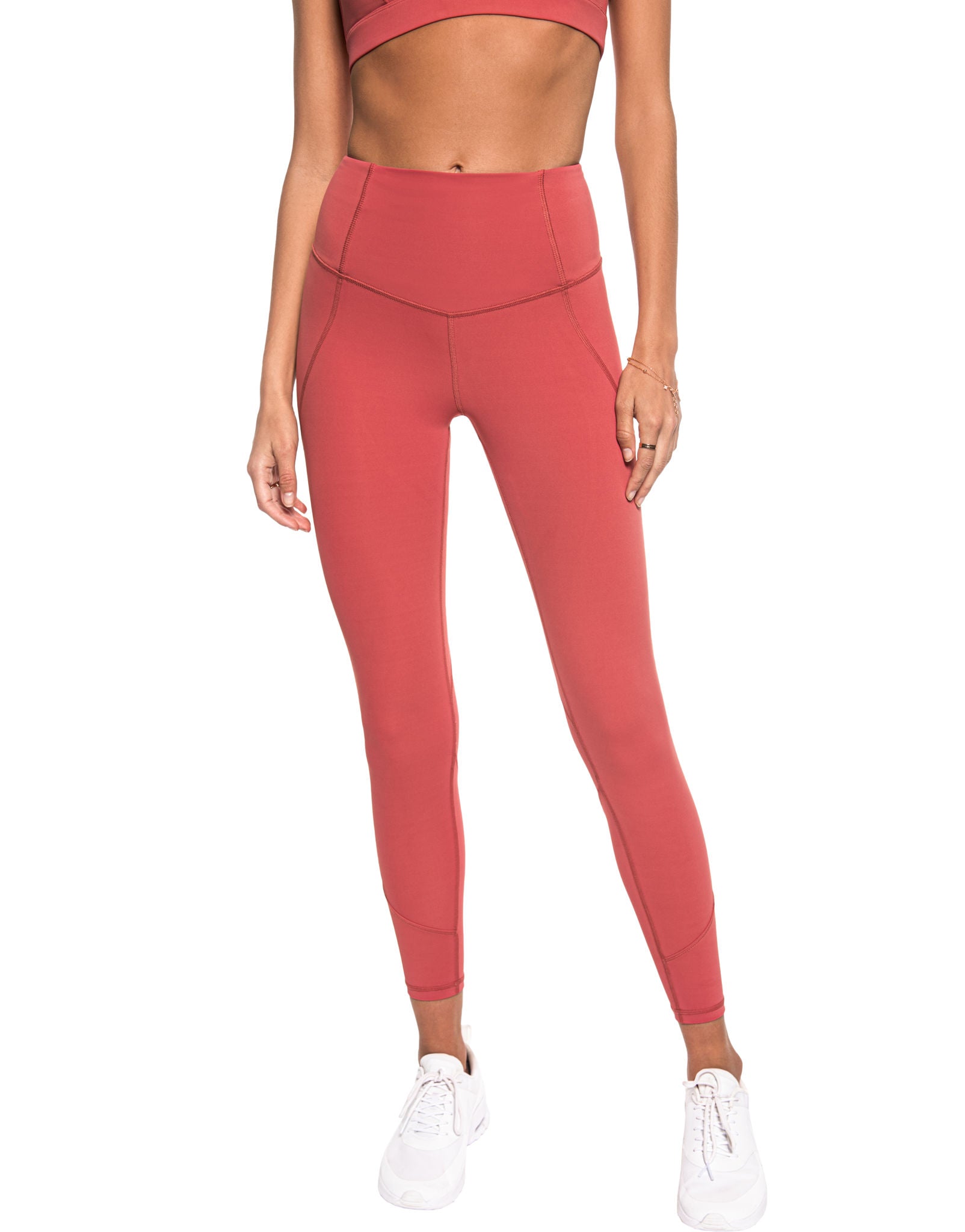 Person wearing coral pink leggings on a white background