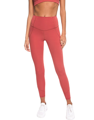Person wearing coral pink leggings on a white background