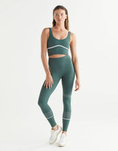 Woman wearing a green athletic outfit on a white background