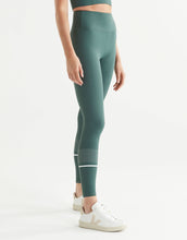 Woman wearing green leggings with a white background