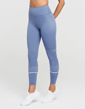 Blue leggings worn by a person on a white background
