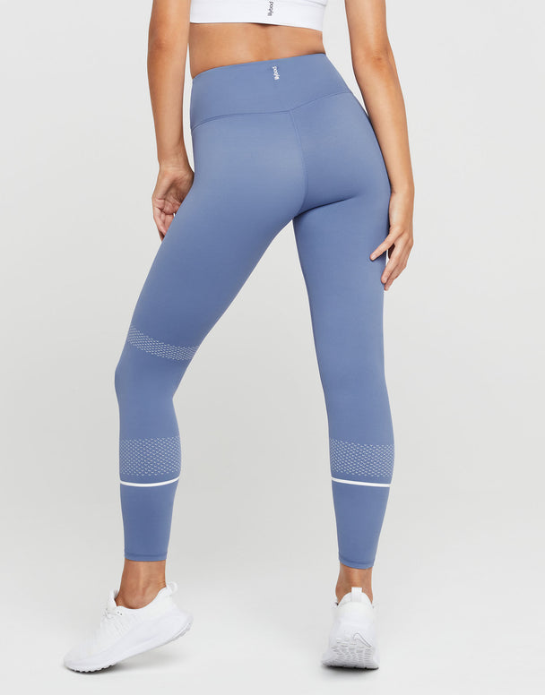 Blue leggings with white accents worn by a person on a white background