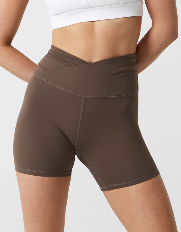 Brown athletic shorts worn by a person on a white background
