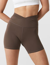 Brown athletic shorts worn by a person on a white background