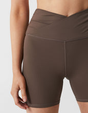 Brown athletic shorts worn by a person on a light gray background