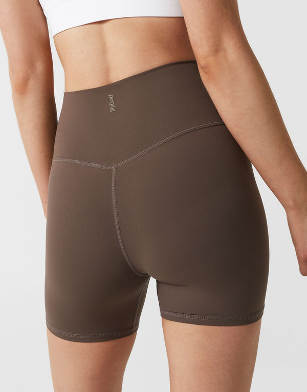 Brown athletic shorts worn by a person on a light gray background