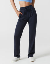 navy blue joggers on a woman against a grey background