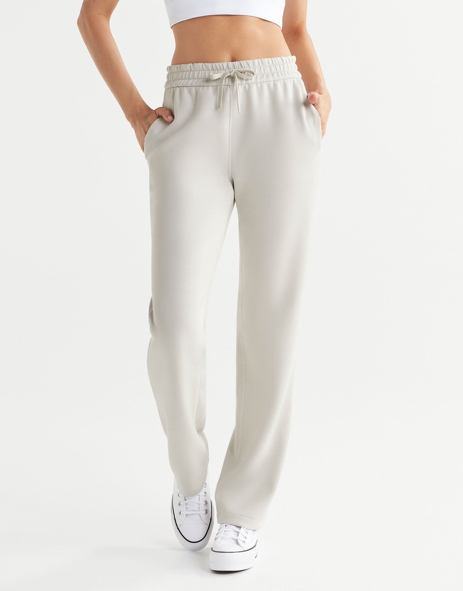 Beige sweatpants worn by a person on a white background