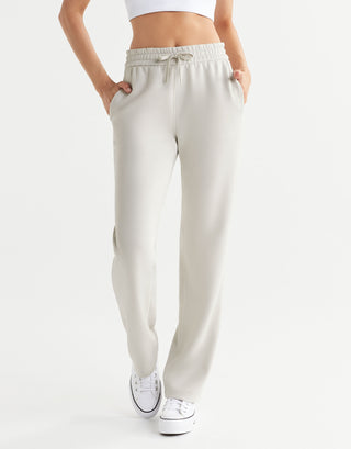 Beige sweatpants worn by a person on a white background