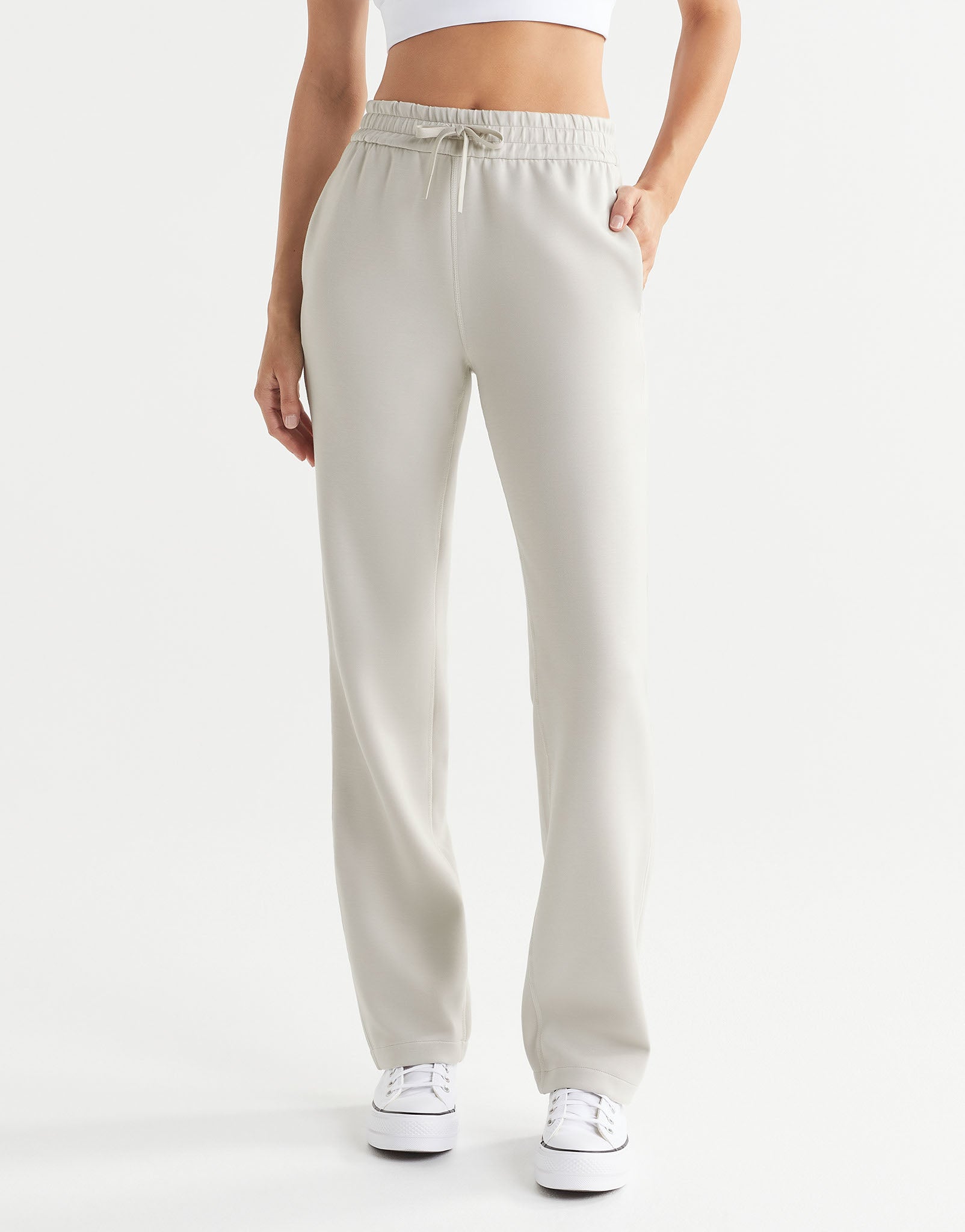 Beige sweatpants worn by a person on a white background
