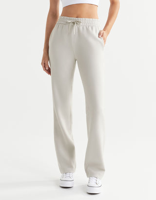 Beige sweatpants worn by a person on a white background