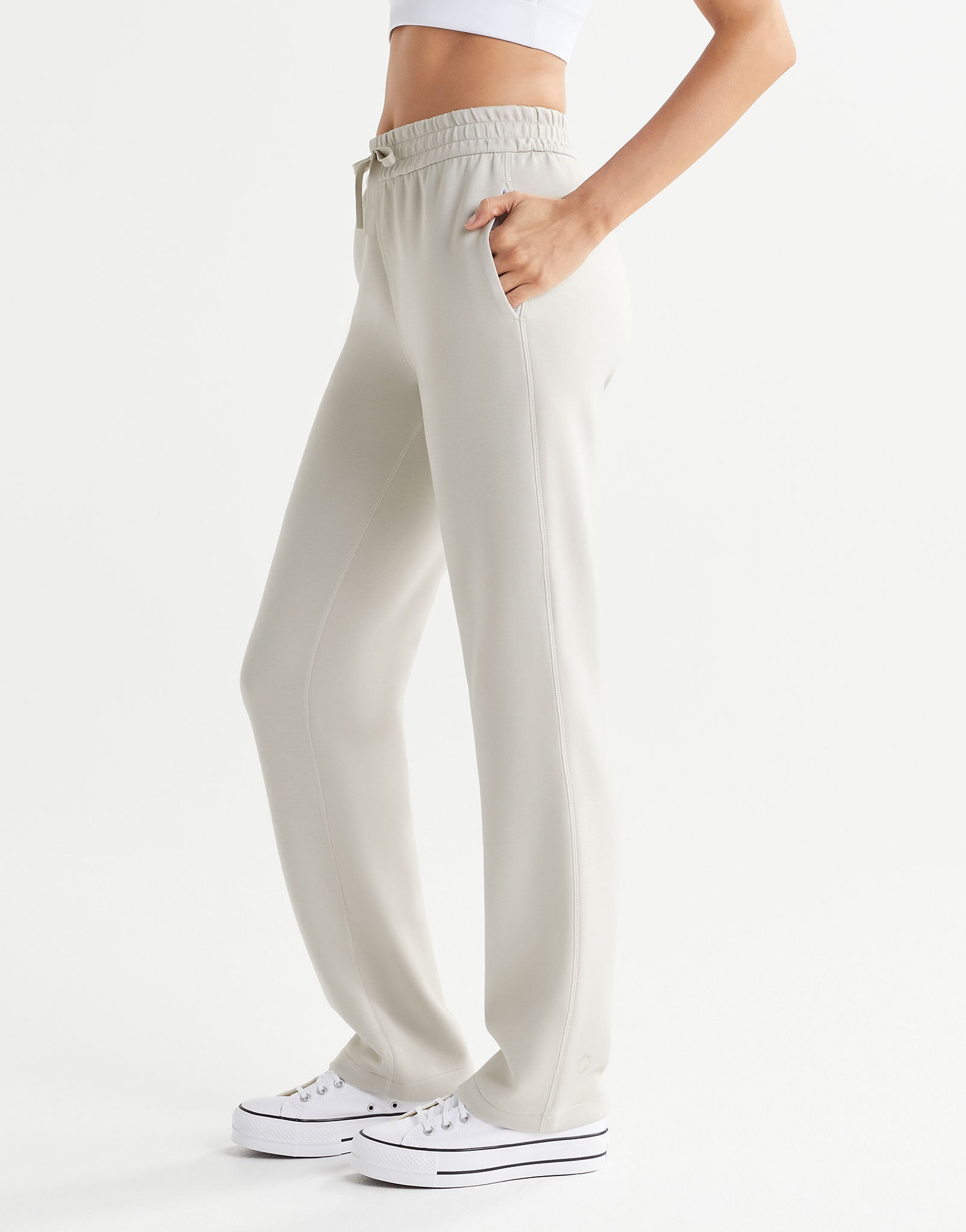 Beige sweatpants worn by a person on a white background