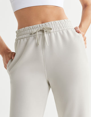Beige sweatpants worn by a person on a white background