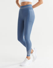 Person wearing blue leggings with a white background