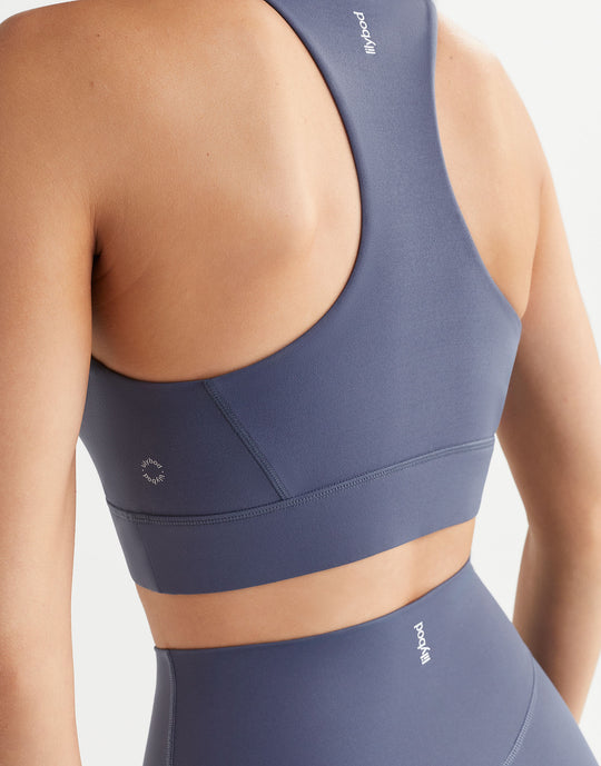 Navy blue sports bra and leggings set on a neutral background