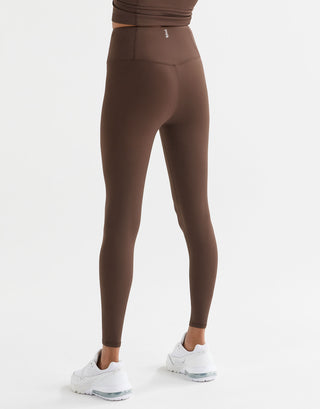 A woman wearing Lilybod Astrid Oak leggings and white sneakers.