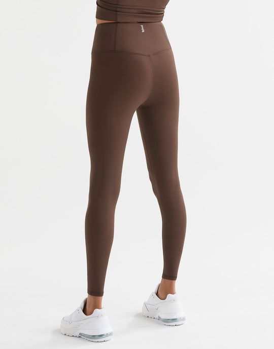 A woman wearing Lilybod Astrid Oak leggings and white sneakers.