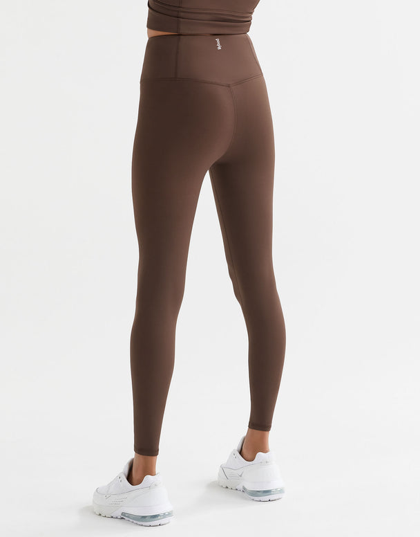A woman wearing Lilybod Astrid Oak leggings and white sneakers.