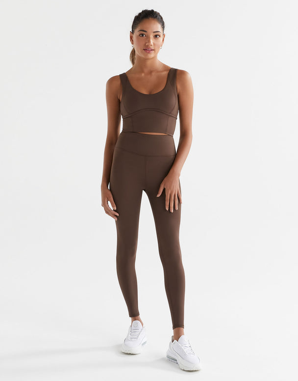 A woman wearing Lilybod Astrid Oak leggings and a matching sports bra.
