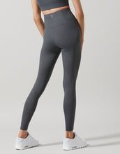 Person wearing gray leggings on a light gray background