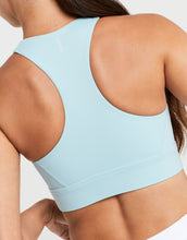 Light blue sports bra worn by a person on a plain background