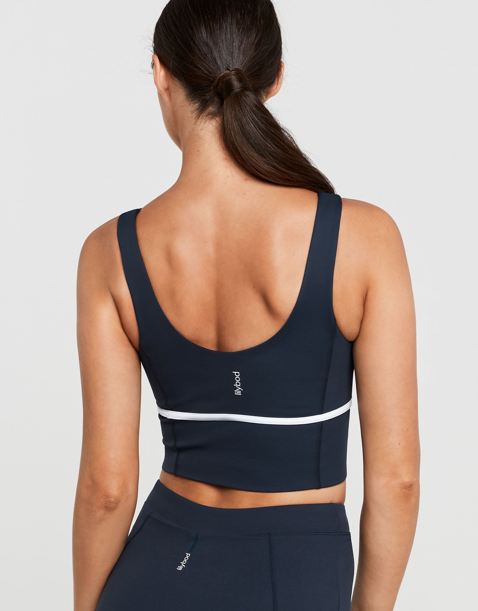 Navy sports bra with white stripe on a plain background