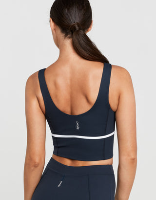 Navy sports bra with white stripe on a plain background