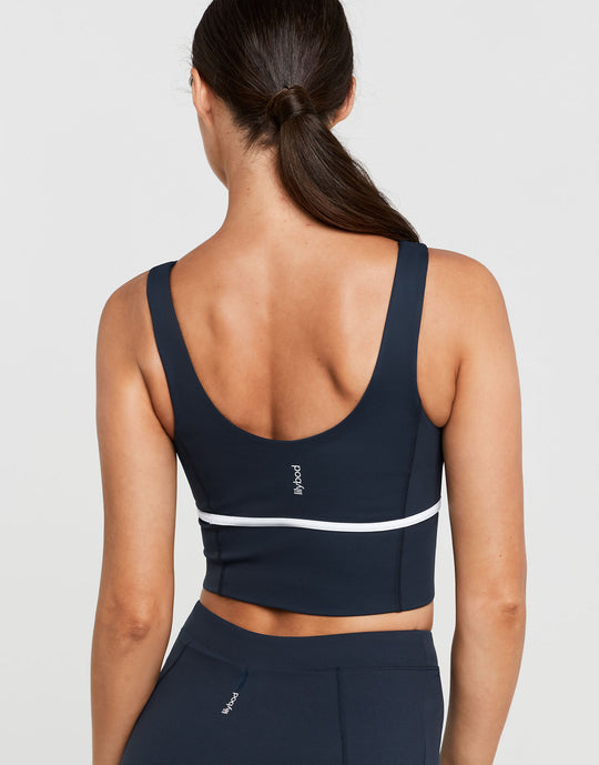 Navy sports bra with white stripe on a plain background