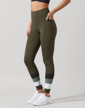 Person wearing olive green leggings with a white background