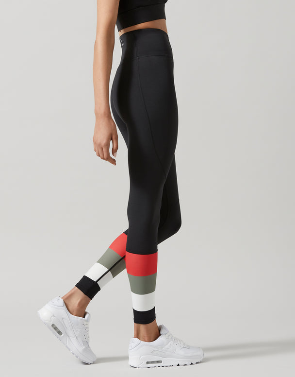 Person wearing black leggings with colorful panels on a gray background