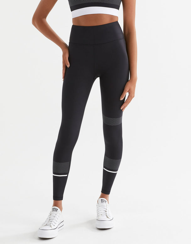 A pair of high-waisted full length leggings in black with white contrast stripes and mesh details. The brand logo 'Lilybod' is visible at the center.