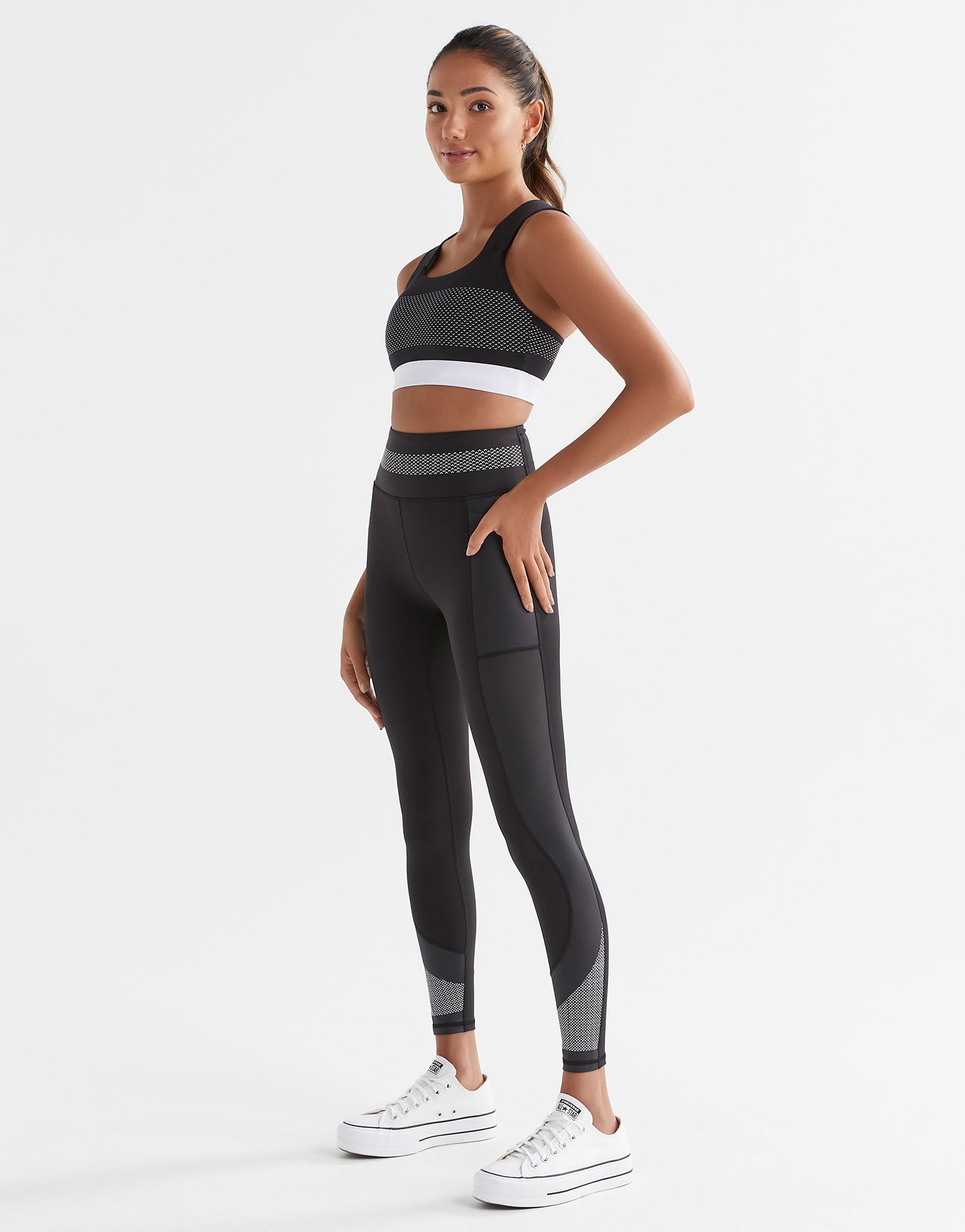 A model wearing a black and white activewear set.