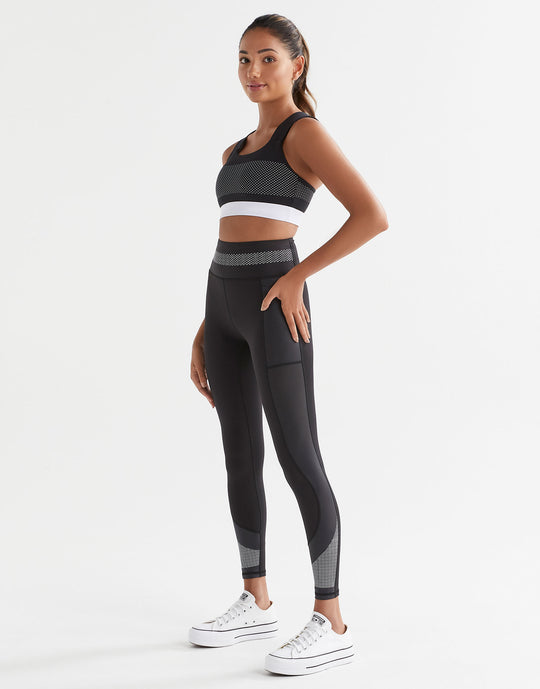 A model wearing a black and white activewear set.