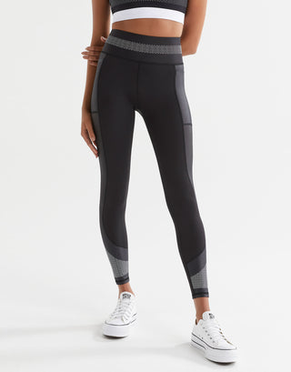 Woman wearing black sporty leggings and white sneakers.