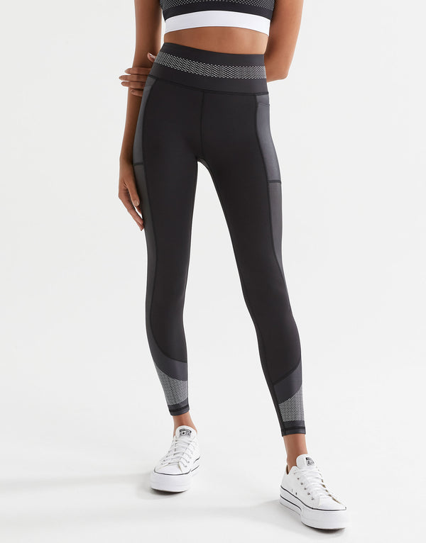 Woman wearing black sporty leggings and white sneakers.