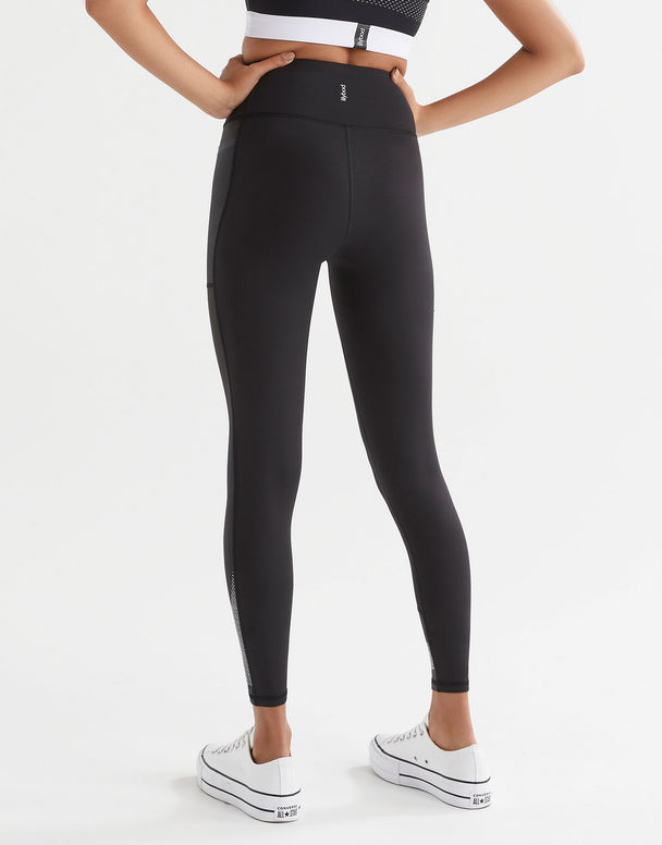 Woman wearing black sporty leggings and white sneakers. Rear view.